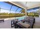 Inviting screened-in patio with a swimming pool, spa, and outdoor seating, all overlooking a beautiful lake view at 826 Honeyflower Loop, Bradenton, FL 34212