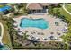 Aerial view of a large swimming pool with chairs, tables, and umbrellas; a relaxing oasis at 826 Honeyflower Loop, Bradenton, FL 34212