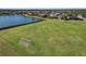 Aerial view of a large community recreation field with soccer goals, adjacent to a lake and residential area at 826 Honeyflower Loop, Bradenton, FL 34212
