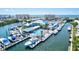 Scenic aerial shot of a coastal yacht club featuring docks, boats, and a sparkling pool, all with ocean views at 830 Trento Dr, Venice, FL 34285