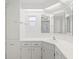 All-white bathroom with vanity, storage, and lots of mirrors at 830 Trento Dr, Venice, FL 34285