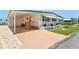 Home with carport, ramp and steps up to the front door, and manicured lawn at 830 Trento Dr, Venice, FL 34285