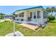 Well-maintained house with lush landscaping, awnings, and white stone features at 830 Trento Dr, Venice, FL 34285