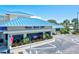 Well-maintained yacht club with a striking blue roof, lush landscaping, and ample parking at 830 Trento Dr, Venice, FL 34285