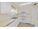 Bright kitchen with white cabinets and appliances, featuring a double sink and tile backsplash at 830 Trento Dr, Venice, FL 34285