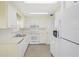 Functional kitchen with white appliances, neutral cabinets, and ample counter space at 830 Trento Dr, Venice, FL 34285