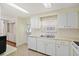 Well-lit kitchen with white appliances and cabinets, complemented by a view to the outdoor area at 830 Trento Dr, Venice, FL 34285