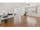 Bright living room featuring wood floors, a ceiling fan, and sliding glass doors to the patio at 830 Trento Dr, Venice, FL 34285