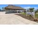 The Oasis sign featuring a thatched picnic shelter and tables by the pool at 830 Trento Dr, Venice, FL 34285