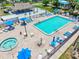 Community pool and spa area featuring a tiki bar, lounge chairs, and umbrellas for relaxation and socializing at 830 Trento Dr, Venice, FL 34285