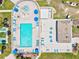 Aerial view of a community pool featuring lounge chairs, umbrellas, a spa, and a tiki hut for residents enjoyment at 830 Trento Dr, Venice, FL 34285