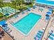 Community pool with lounge chairs and umbrellas, alongside shuffleboard courts, offering a relaxing and active lifestyle at 830 Trento Dr, Venice, FL 34285