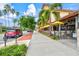 A charming sidewalk view featuring tropical landscaping and outdoor restaurant seating at 830 Trento Dr, Venice, FL 34285