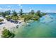 Lively waterfront scene with people enjoying the clear water, sandy beach, and lush greenery at 830 Trento Dr, Venice, FL 34285