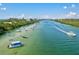 Scenic view of a waterway filled with boats, surrounded by lush greenery, under a partly cloudy sky at 830 Trento Dr, Venice, FL 34285