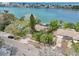 Aerial view showcases a residential waterfront property surrounded by lush trees and greenery at 9300 Gulf Blvd, St Pete Beach, FL 33706