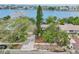 Aerial shot showcases a home with waterfront view, driveway, and surrounding trees at 9300 Gulf Blvd, St Pete Beach, FL 33706