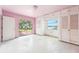 Bedroom with access to the yard, closets, windows, and painted pink walls and floor at 9300 Gulf Blvd, St Pete Beach, FL 33706