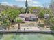 Waterfront single-story home featuring a private dock and concrete waterfront patio at 9300 Gulf Blvd, St Pete Beach, FL 33706