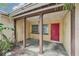 Open front porch with weathered columns and a bright red door, ready for a refresh at 9300 Gulf Blvd, St Pete Beach, FL 33706