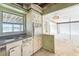 A vintage kitchen features outdated appliances, worn cabinets, and a view into an adjacent room requiring refurbishment at 9300 Gulf Blvd, St Pete Beach, FL 33706