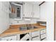 Outdated kitchen features include a double sink, white cabinets, and a wood countertop at 9300 Gulf Blvd, St Pete Beach, FL 33706