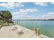 Waterfront property with a small concrete area, palm trees, and a tranquil waterfront view at 9300 Gulf Blvd, St Pete Beach, FL 33706