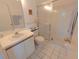 Well-lit bathroom with shower, toilet, sink, and white cabinets and tile at 967 Waterside Ln # 1, Bradenton, FL 34209