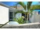 Courtyard with palm tree, tropical plants, and partial stucco wall at 967 Waterside Ln # 1, Bradenton, FL 34209