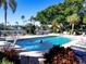 Resort-style community pool with lounge chairs, shade umbrellas, and lush tropical landscaping at 967 Waterside Ln # 1, Bradenton, FL 34209