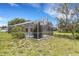 Backyard with a screened pool area surrounded by lush greenery at 1026 Graham Rd, Venice, FL 34293