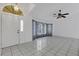 Bright foyer featuring white tile flooring, a decorative ceiling fan, and a stylish front door at 1026 Graham Rd, Venice, FL 34293