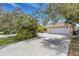 Lovely home featuring an attached three-car garage and an extra long driveway, surrounded by mature trees and landscaping at 1026 Graham Rd, Venice, FL 34293