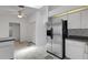 Stainless steel refrigerator in bright kitchen with white cabinets and tile floor at 1026 Graham Rd, Venice, FL 34293