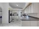 Bright kitchen featuring white cabinets, stainless steel appliances, and unique tile flooring design at 1026 Graham Rd, Venice, FL 34293