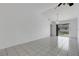Spacious living room featuring tile floors, white walls, and a sliding door to the screened lanai at 1026 Graham Rd, Venice, FL 34293