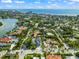 A coastal neighborhood with a modern white home nestled among palm trees and colorful residences near a beautiful ocean at 128 Fillmore Dr, Sarasota, FL 34236