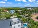 Aerial view of a white three-story home with rooftop deck, balconies, spiral staircase, and a refreshing pool area at 128 Fillmore Dr, Sarasota, FL 34236