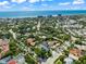 Coastal community aerial view featuring a modern three-story white home among palm trees and neighboring residences at 128 Fillmore Dr, Sarasota, FL 34236