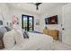Bright bedroom with a ceiling fan, balcony access, comfortable bed, and entertainment center at 128 Fillmore Dr, Sarasota, FL 34236