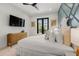 Inviting bedroom featuring a statement wall, comfortable bed, balcony access, and entertainment center at 128 Fillmore Dr, Sarasota, FL 34236