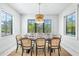 Bright dining room with a stylish table and seating for six, illuminated with modern lighting at 128 Fillmore Dr, Sarasota, FL 34236