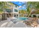 Elegant home exterior boasting a serene pool area, spiral staircase, and covered outdoor seating, ideal for relaxation and entertainment at 128 Fillmore Dr, Sarasota, FL 34236