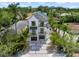 Aerial view of a modern white three-story home with a dark roof, front-facing two-car garage and balconies at 128 Fillmore Dr, Sarasota, FL 34236