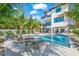 Stunning home exterior with a pool, lounge chairs, lush palm trees, and spiral staircase, offering luxurious outdoor living at 128 Fillmore Dr, Sarasota, FL 34236