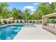 Inviting backyard featuring a refreshing pool, sun loungers, and lush tropical landscaping, creating a perfect outdoor oasis at 128 Fillmore Dr, Sarasota, FL 34236