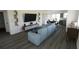 Open-concept living area with a large sectional sofa, modern entertainment center, and dining space nearby at 13046 Bayberry Way, Parrish, FL 34219