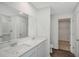 Modern bathroom featuring double sinks, a large mirror, and access to a walk-in closet for added convenience at 13117 Bayberry Way, Parrish, FL 34219