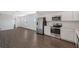 Open-concept living space featuring a kitchen with stainless steel appliances and dark wood flooring throughout at 13136 Bayberry Way, Parrish, FL 34219