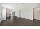 Bright and airy living area leading to the kitchen, featuring dark wood flooring and neutral walls throughout at 13136 Bayberry Way, Parrish, FL 34219